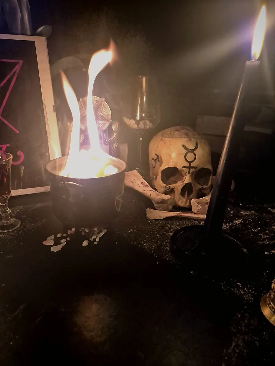 Preparazione rituale con candele e fiamma su altare